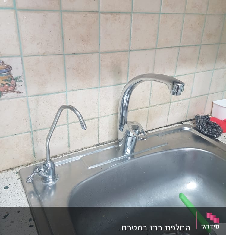 ברזים נירוסטה מעל כיור מטבח עם מסננת